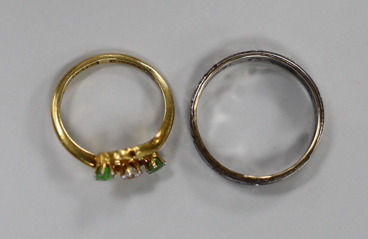 An 18ct and pt, diamond and green garnet set three stone crossover ring, size I/J, gross 2.5 grams and one other ring stamped '9ct and silver'.